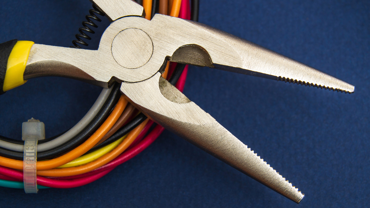 A pair of pliers sitting on top of a bunch of wires